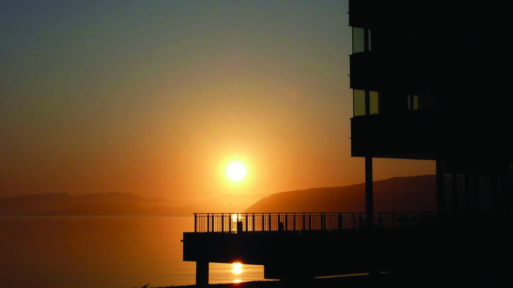 Utsikt mot havet på vinteren med Midnattsol på Thon Hotel Kirkenes, som ligger på kaia i Kirkenes sentrum